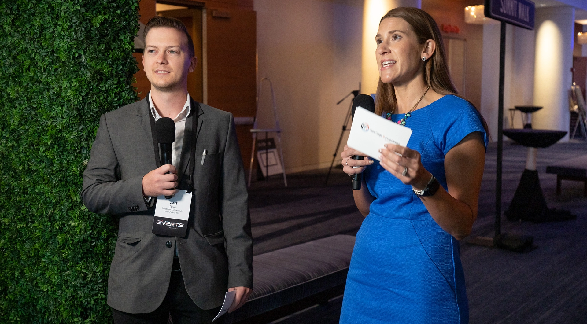 Man and woman holding microphones and on camera