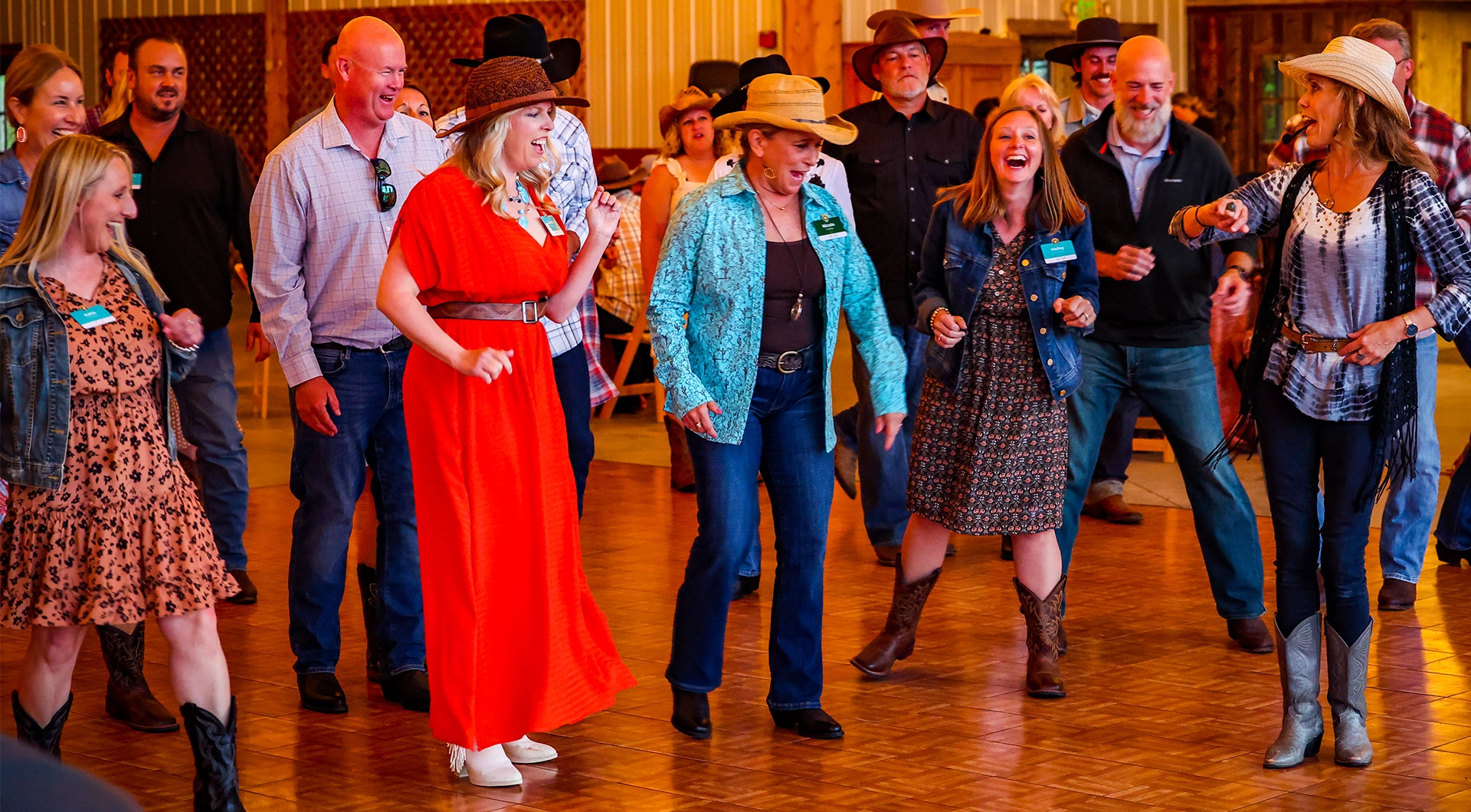 Group of people learning to line dance at an event.