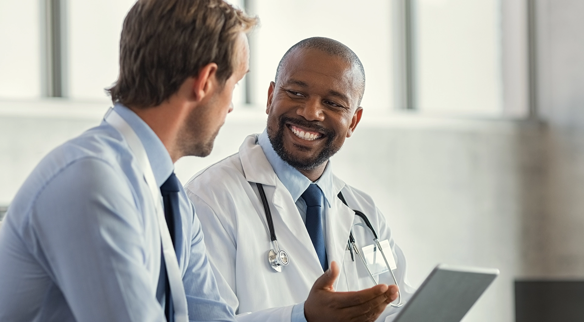 Doctor and medical team member smiling and having a conversation.