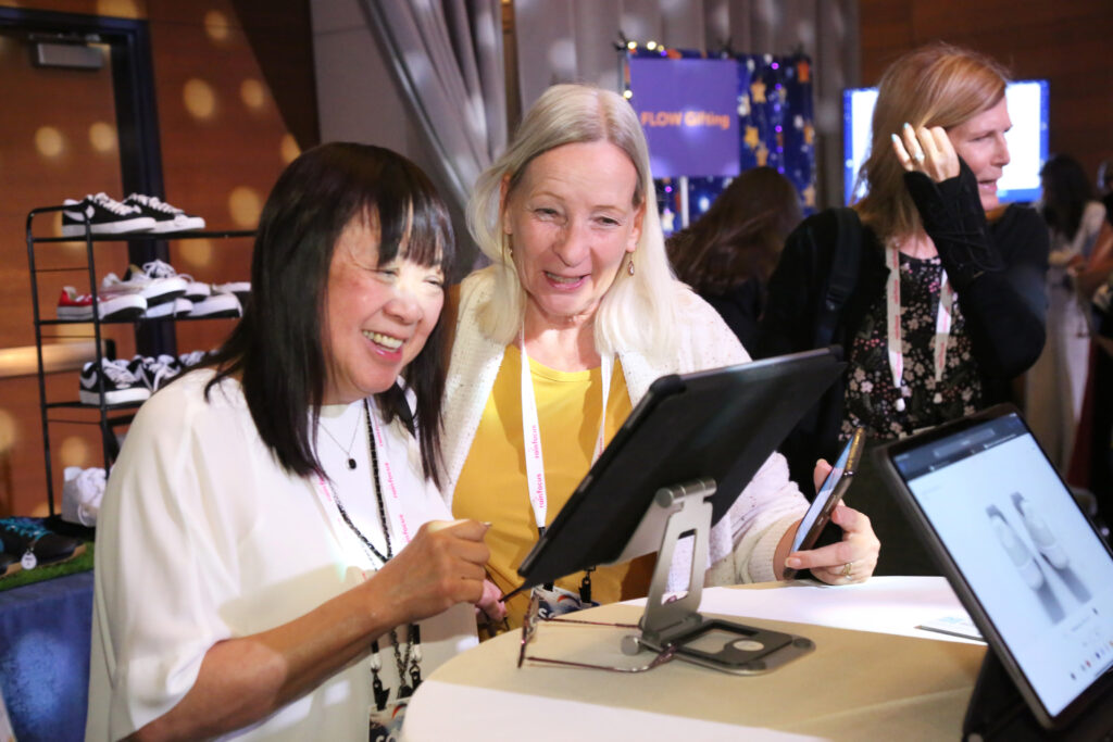 Two attendees using a tablet at the 2024 M&IW Summit