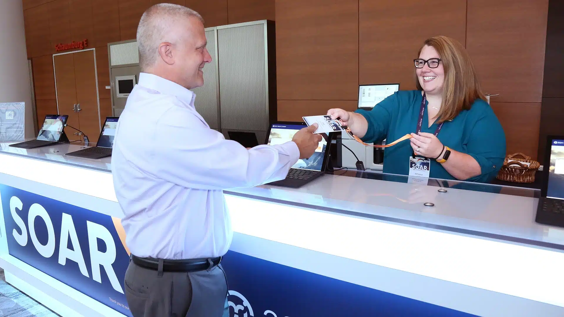 Man checking in at the 2024 M&IW Summit getting his nametag.