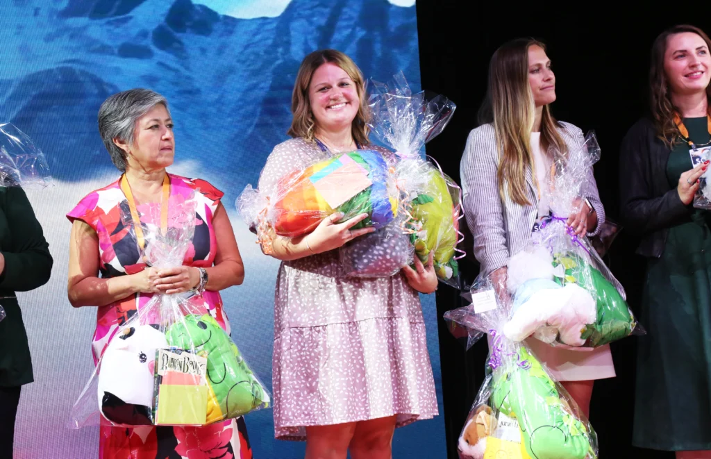 Event attendees onstage with care packages prepared during an event