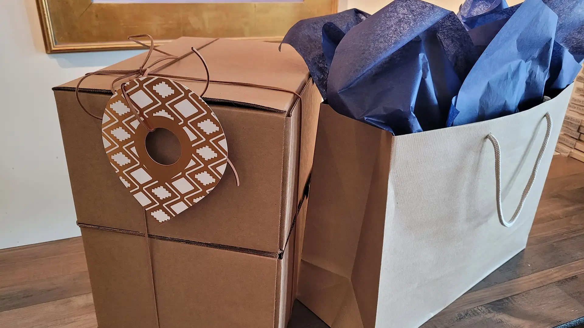 Elite experience gifts wrapped in boxes and a gift bag with the custom die cut card hanging from the wrapped box.