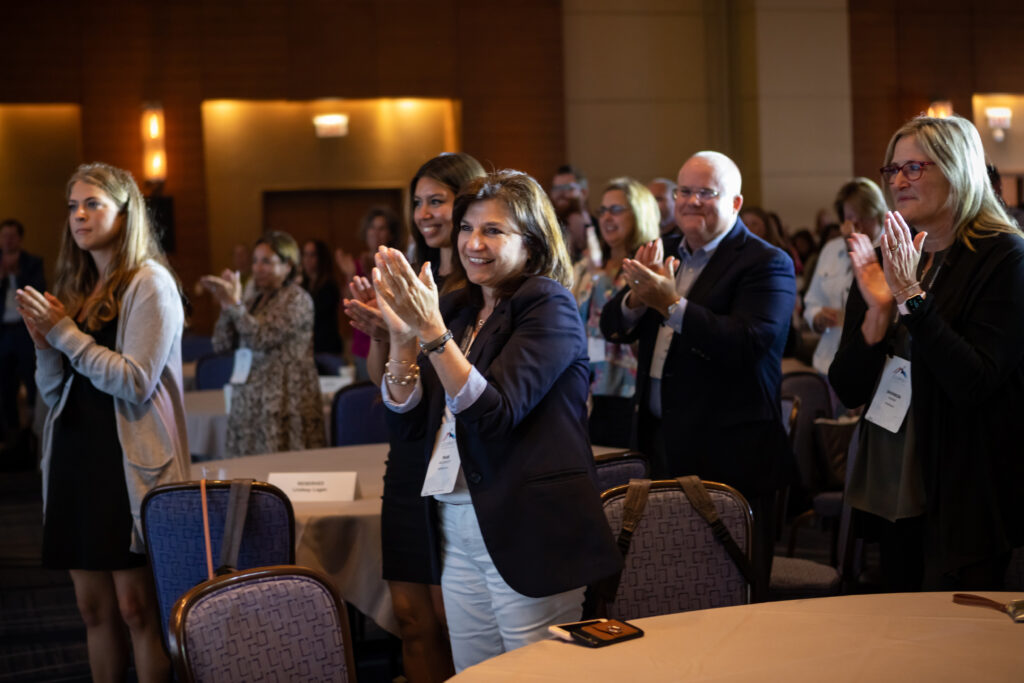 Attendees give a standing ovation at the 2022 M&IW Summit