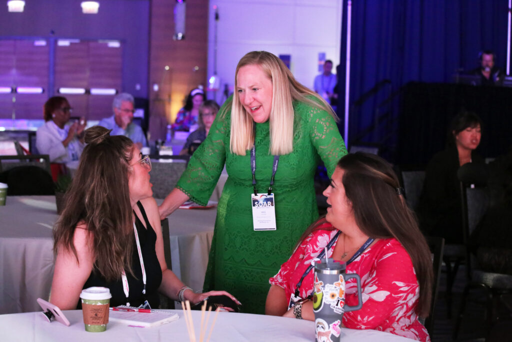 Three attendees talking at the 2024 M&IW Summit