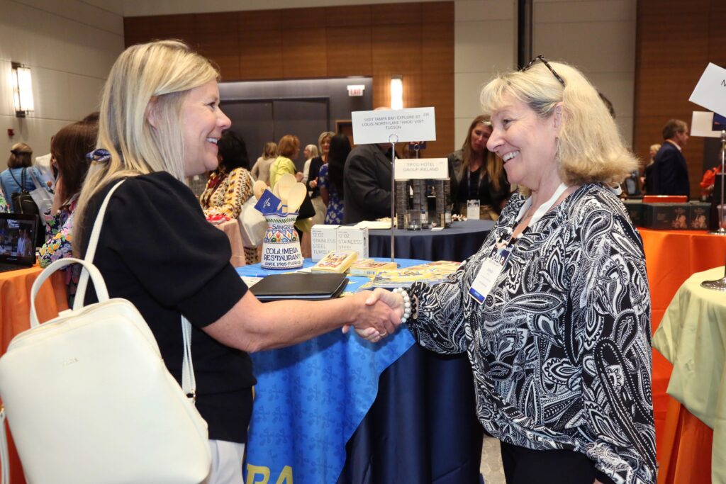 An attendee shaking hands with an exhibitor at the 2024 M&IW Summit