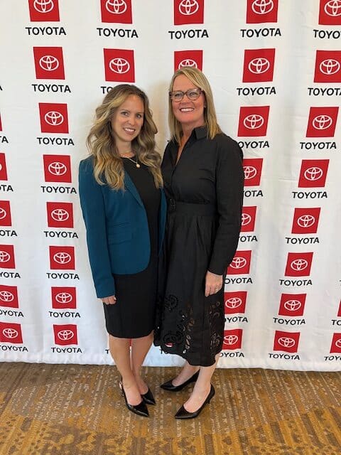 Intent Strategy Group's Laura Rog, left, and Angie Duncan Callaway in front of a Toyota step and repeat at the 2025 SupplierCon
