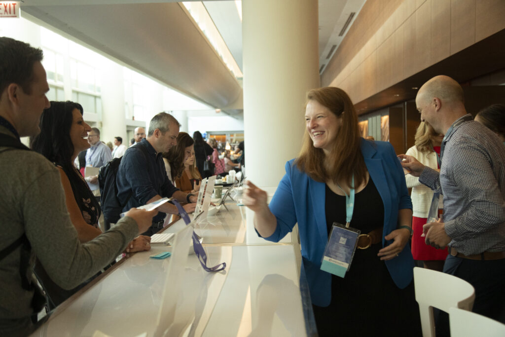 Onsite staff handing attendees name badges at the 2025 M&IW Summit