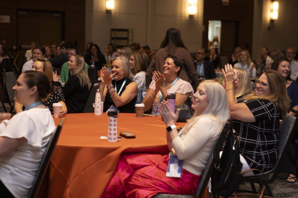 Audience members applauding at the 2025 M&IW Summit