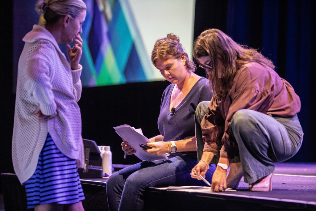 Speakers reviewing their scripts during rehearsals for the 2025 M&IW Summit